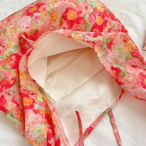 Close-up of floral tote bag interior with shiny lining and a functional zipper pocket