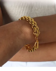 Close-up of golden chunky double-link bracelet with elegant toggle clasp on wrist