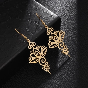Detailed close-up of golden stainless steel hollow lotus mandala earrings on leather