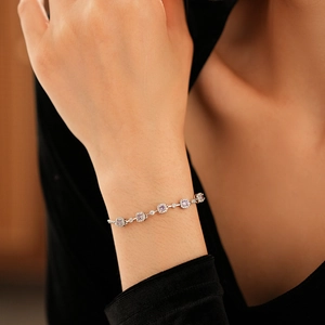 Detail of elegant silver bracelet with lavender square zircons on woman's wrist