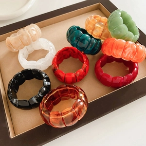 Top view of colorful chunky acrylic geometric stretch bracelets in a texture display tray