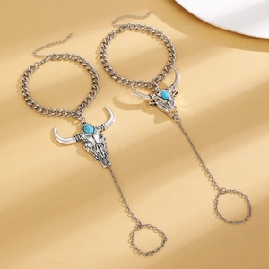 Detail of bohemian silver bracelets with turquoise cow head pendant and finger rings
