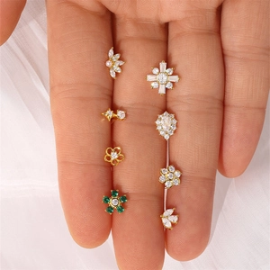 Collection of gold S925 silver stud earrings with zircon and pearls on white silk