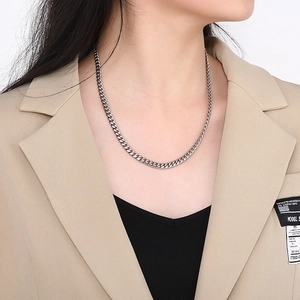 Close-up of minimalist silver titanium steel Cuban chain necklace on model