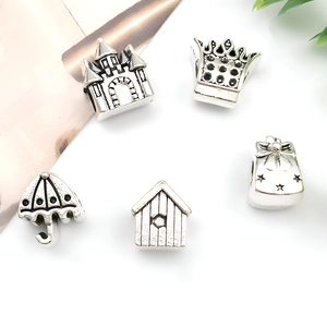 Detail view of antique silver charms including castle, crown, and umbrella for DIY bracelets