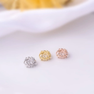 Detailed shot of leaf shaped micro-pave zircon hoop earrings in gold, silver and rose gold