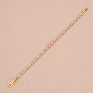 Close-up of gold tennis bracelet featuring pink heart zircons and white square stones