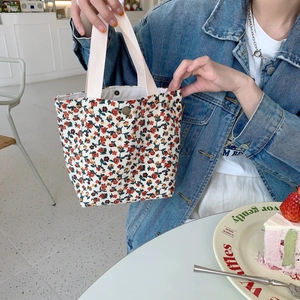 Detailed close-up of floral corduroy tote bag with metal snap button and pink strap