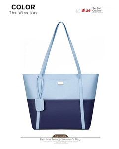 Detail of blue two-tone patchwork tote bag featuring metal logo and leather charm