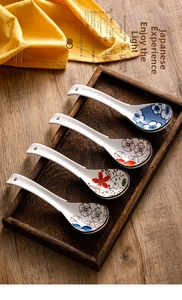 Detail of four hand-painted Japanese ceramic spoons with floral patterns on a wooden tray