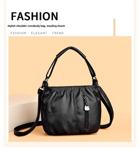 Detail of black pleated crossbody bag featuring soft leather and heart zipper slider