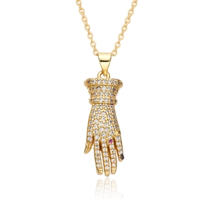 Detailed view of a gold glove pendant with white zircon micro-paving and pink gemstone