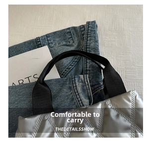 Detail of silver quilted tote bag featuring metallic finish and black nylon handles