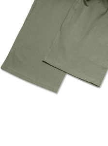 Detailed close-up of army green cotton linen pants showing hem stitching and fabric texture