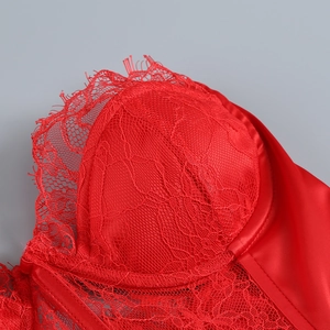 Vue macro de dentelle rouge et de satin lisse sur les coutures du haut bustier