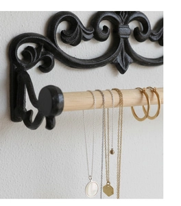 Detail der Vintage-Wandhalterung aus Gusseisen mit Holzstange für edlen Schmuck