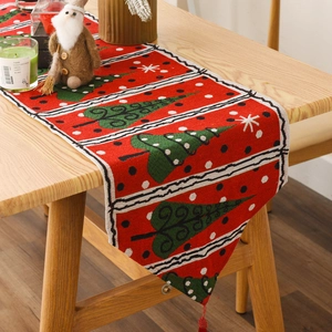 Close-up of red knitted Christmas table runner with pine tree patterns and red tassels