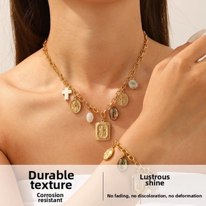 Detail view of gold layered necklace set with religious medals and cross charms