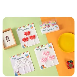 Set of cute cartoon bow and cloud shaped birthday cake candles in retail packaging