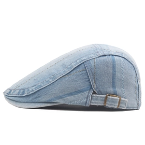 Detailed side view of washed denim beret featuring vintage brass adjustable buckle and stitching