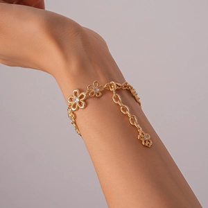 Close-up of gold hollow flower bracelet with zircon stones and adjustable extender chain