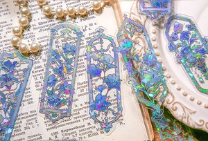Detail of blue flower PET sticker with laser effect on vintage paper and pearl display