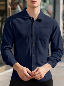 Detail of navy blue linen shirt showing seersucker fabric texture and sleeve button tab
