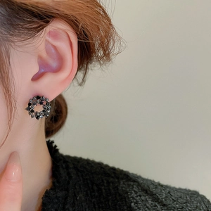 Close-up of a vintage black crystal circle earring worn by a model in a side profile