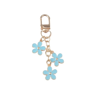 Golden keychain with blue flower charms featuring metallic edges and a spring clasp