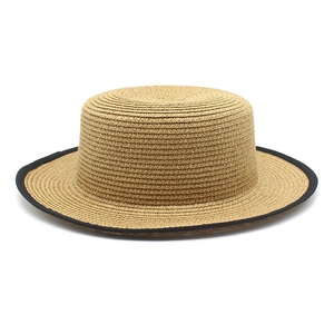 Detail of natural straw weave and black ribbon edge on a classic flat top boater hat