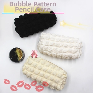 Detailed texture of popcorn quilted pencil cases in black, white, and cream beige colors