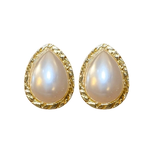 Vintage gold teardrop earrings with faux pearls and textured metal frames on white background
