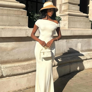 Détail d'une élégante robe longue ivoire à épaules dénudées avec texture plissée fine