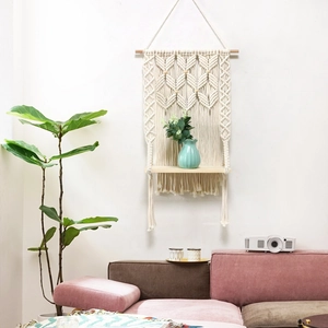 Hand-woven cotton rope tapestry shelf with natural wood board in a cozy living room scene
