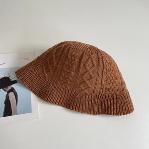 Macro detail of caramel cable knit texture and ribbed edge on a summer bucket hat