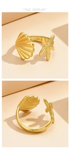 Detailed view of ocean theme gold star and seashell charms on an adjustable ring band
