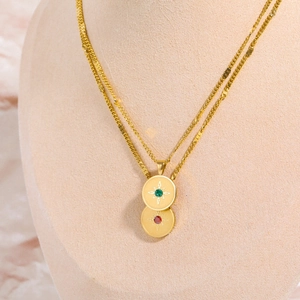 Detail of 18K gold-plated stainless steel star necklace with red and green birthstones