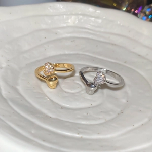Detailed view of 18k gold and silver plated heart rings with pavé zircon accents