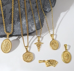 Detailed collection of vintage gold stainless steel star and angel necklaces on stone