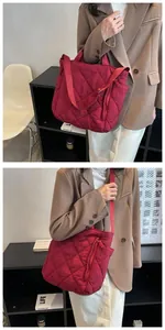 Detail view of red quilted tote bag with side zipper pocket and adjustable strap