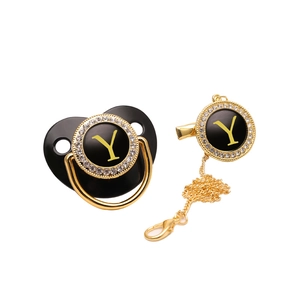 Detailed view of luxury black and gold pacifier with letter Y and rhinestone accents