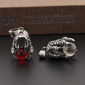 Detailed view of dragon claw pendants holding red and clear crystal beads in retro style
