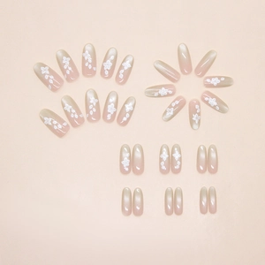 Detail of mint cat eye press-on nails with 3D white floral accents and gradient finish