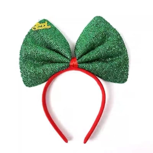 Detail of Christmas headband featuring green glitter bow and gold Merry Christmas text
