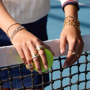 Macro view of stacked mixed-metal rings with white zircons on a tennis court setting