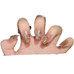 Handmade press-on nails in champagne aurora finish with gold foil and glitter decor