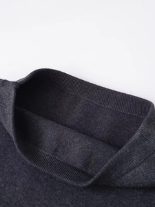 Dettaglio dello scollo in maglia a coste sottili di un gilet grigio scuro chic