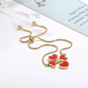 Dettaglio del bracciale a quadrifoglio con cuori rossi, catena oro e chiusura regolabile