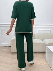 Vue arrière de l'ensemble en tricot vert foncé avec rayures blanches sur le haut et le pantalon