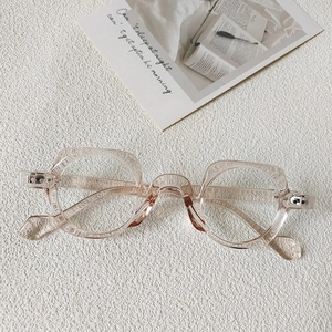 Detail of transparent pink geometric eyeglasses frame with resin texture on white surface
